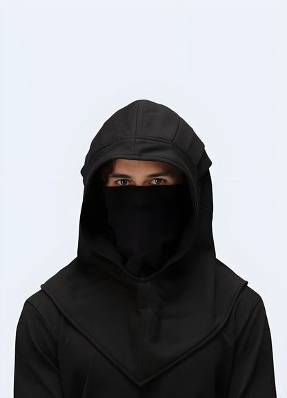 Front view of a man donning a trendy black techwear hood, highlighting its contemporary style and functional features, ideal for UK streetwear.