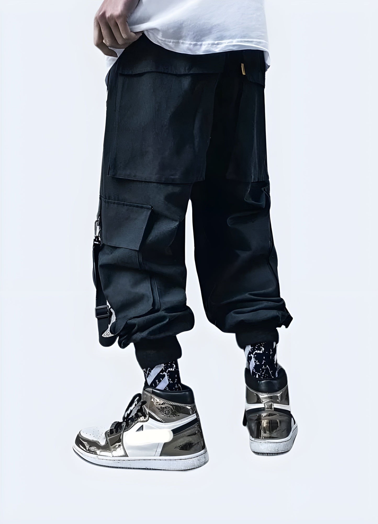 Rear view of man in black techwear cargo pants featuring adjustable straps and pockets, UK fashion.